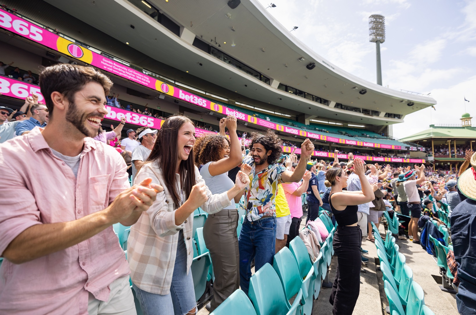 Friends cheering and enjoying a cricket game at the Sydney Cricket Ground